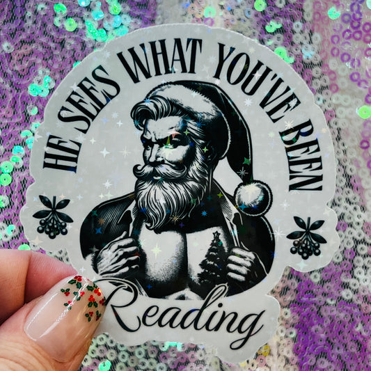 He Sees What You’ve Been Reading Holographic Santa Sticker – Book Lover Holiday Sticker